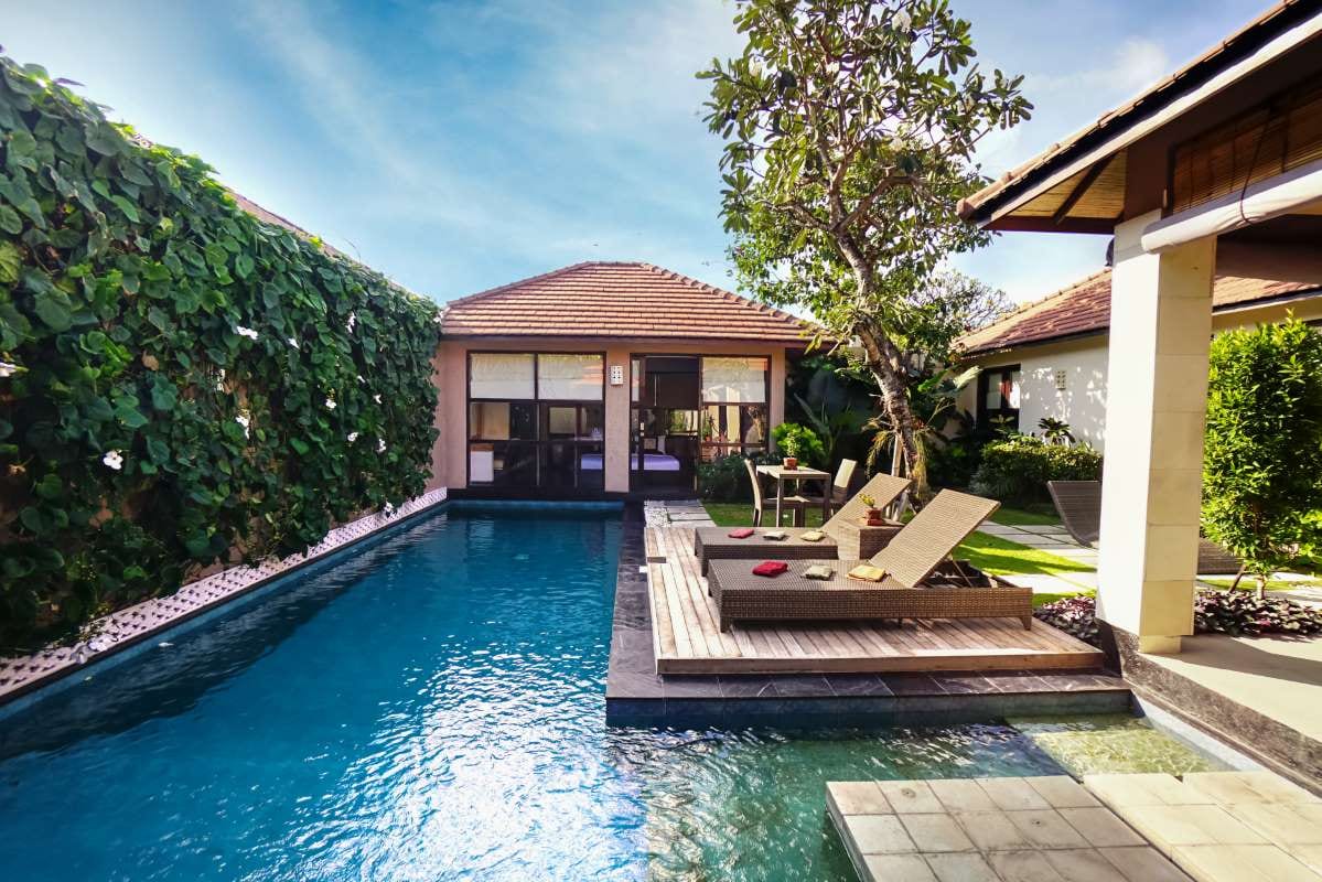 Contemporary home with tropical landscaping and blue pool water