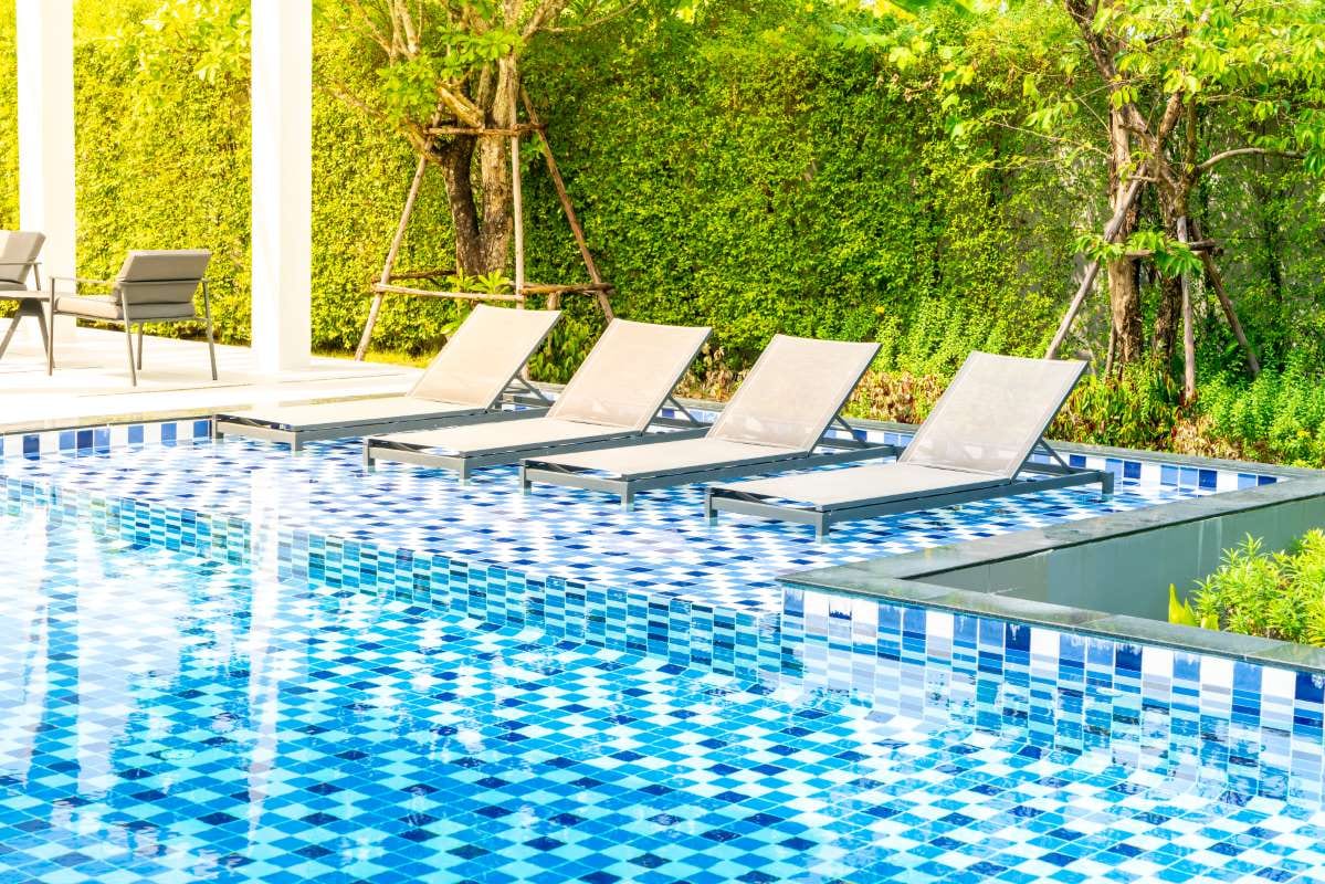 Outdoor hotel pool area with poolside bed seating at a resort