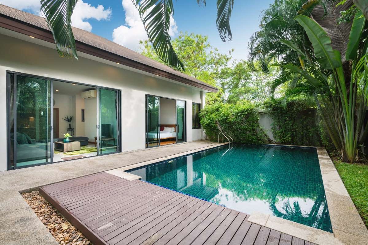Modern villa exterior with swimming pool, garden, and terrace decking