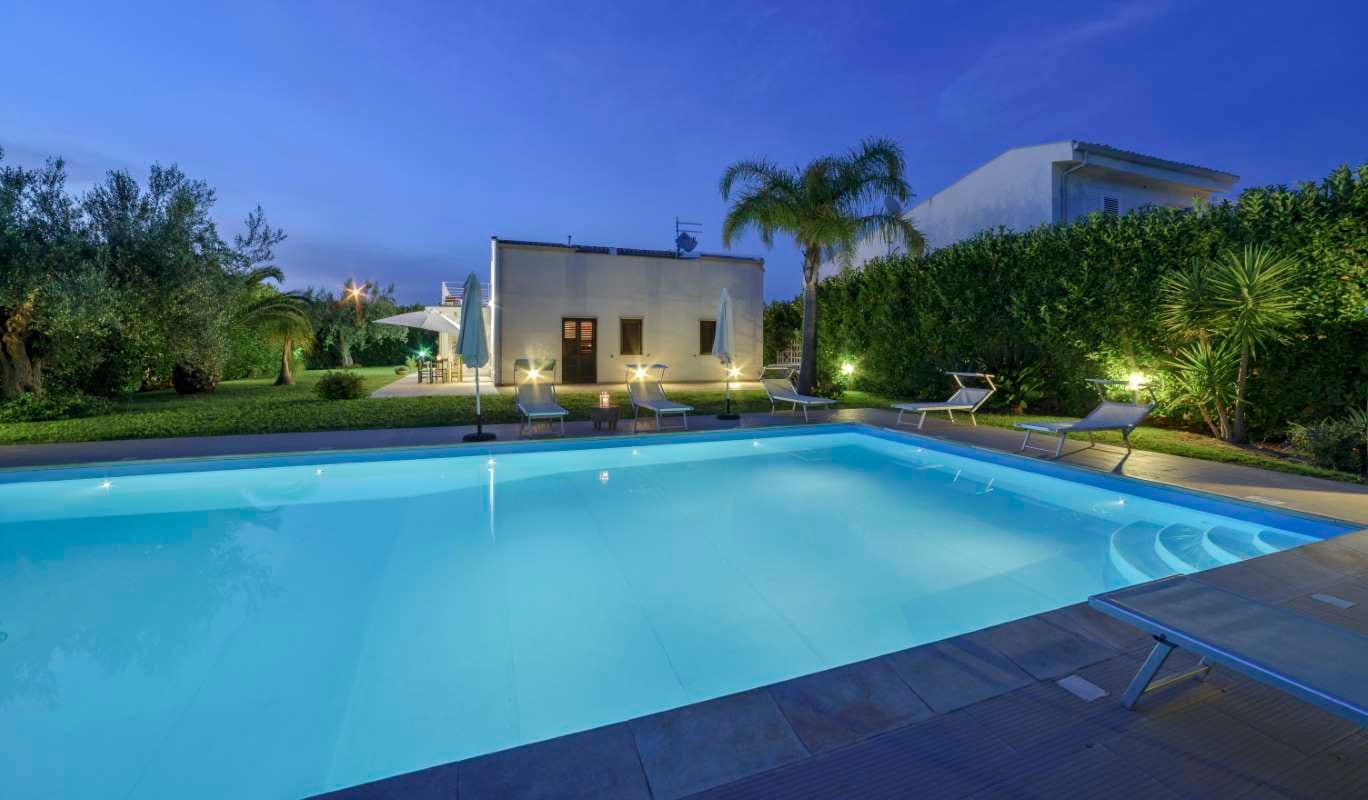 Elegant private house with garden and swimming pool in the Sicilian countryside at sunset