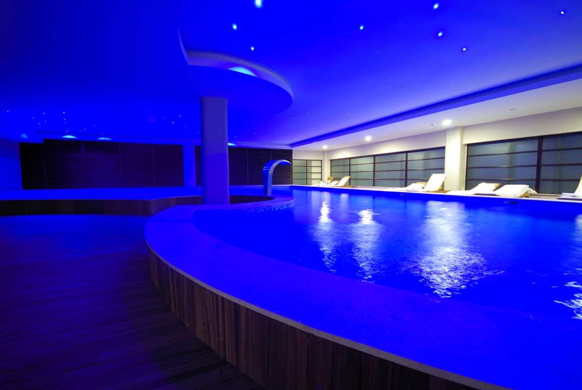 Luxury indoor swimming pool with calm blue water and modern tiled design