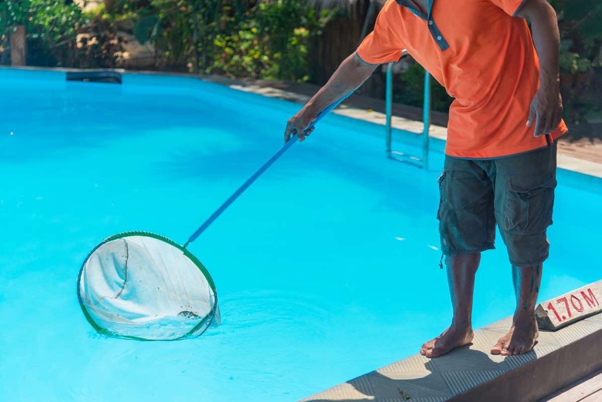Man standing beside a swimming pool, shown from the low section