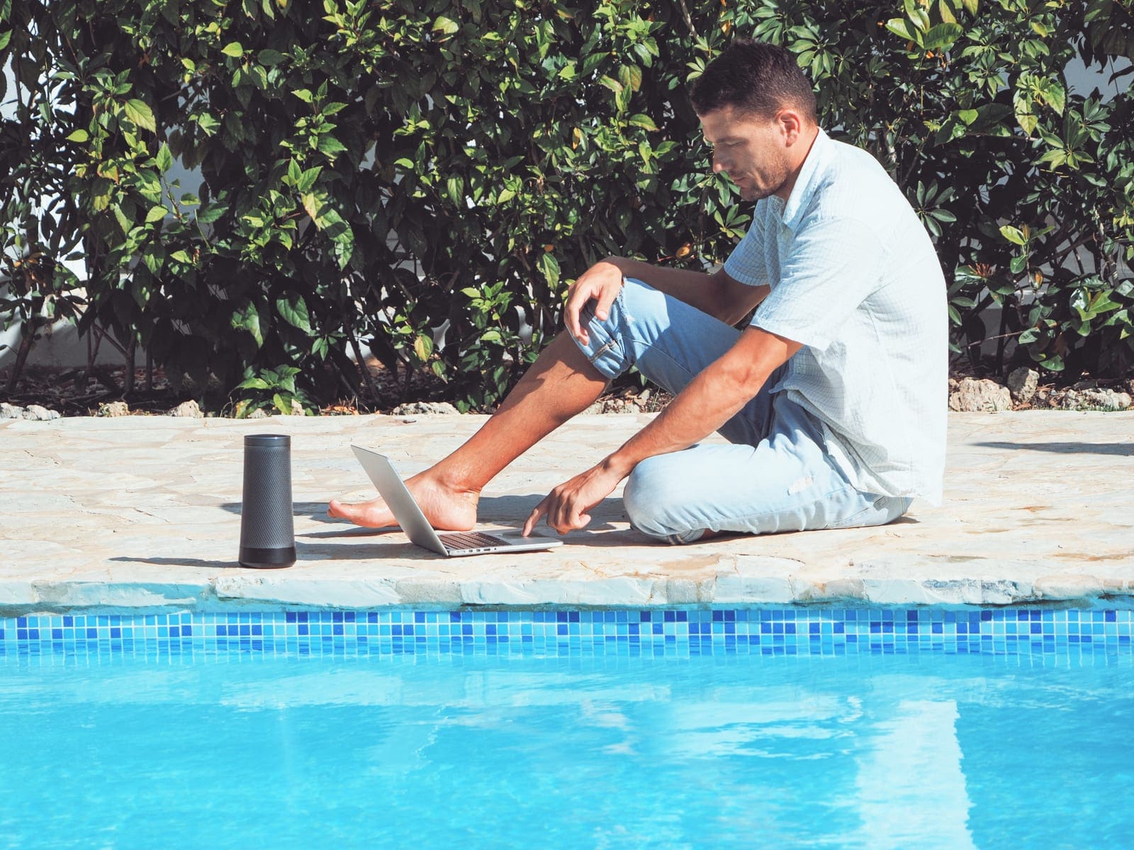 Pool service owner reviewing overdue invoices on a laptop poolside