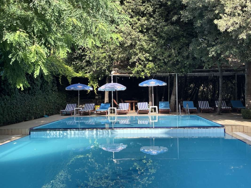 Pool with blue water, umbrellas, and chairs
