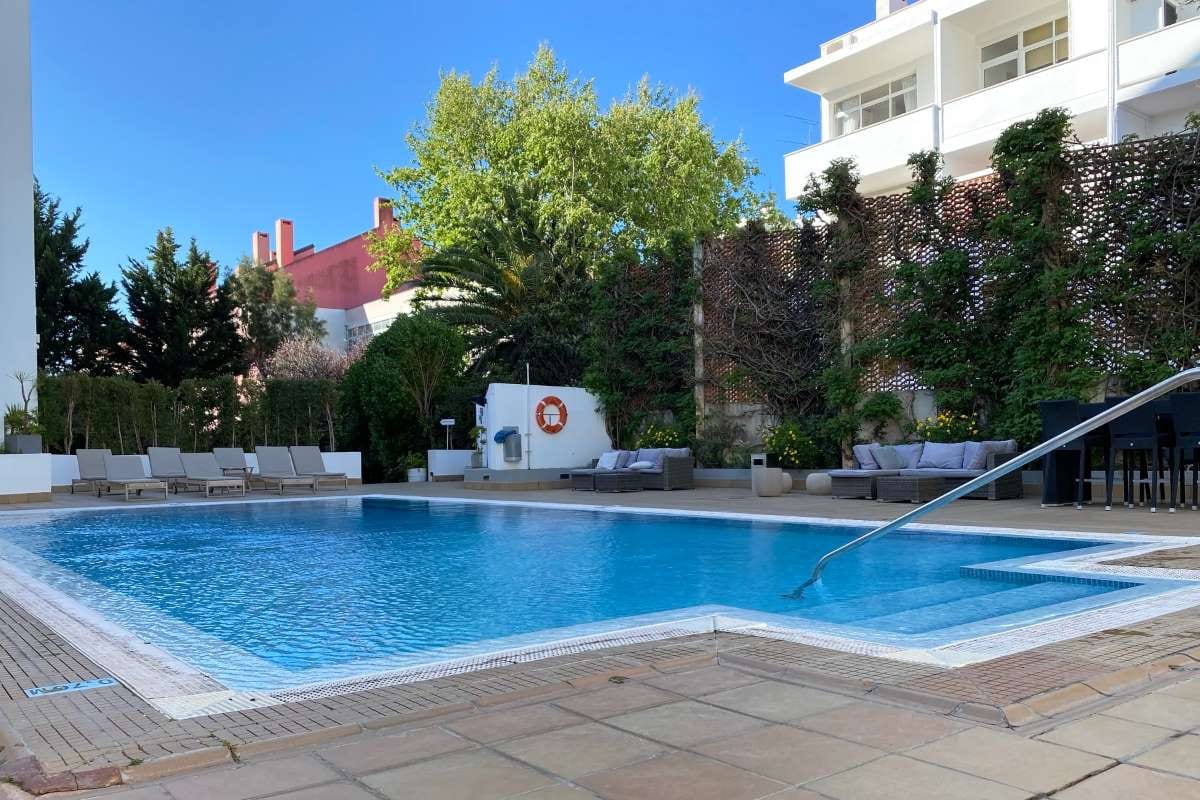 Sunny residential swimming pool in a backyard setting