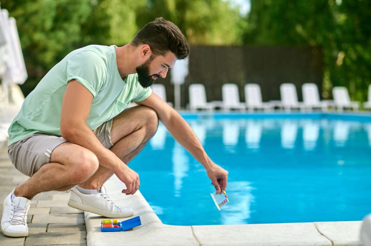 Technician making a water test beside a swimming pool