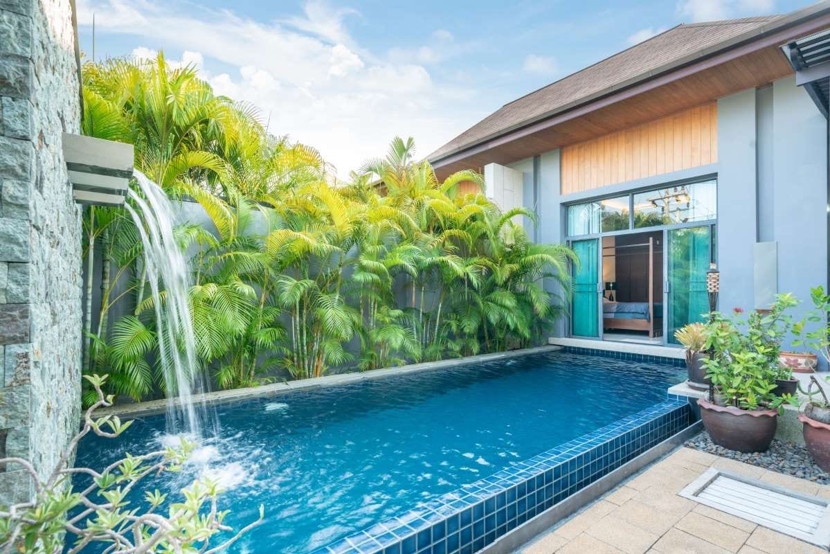 Swimming pool beside a house under a clear sky
