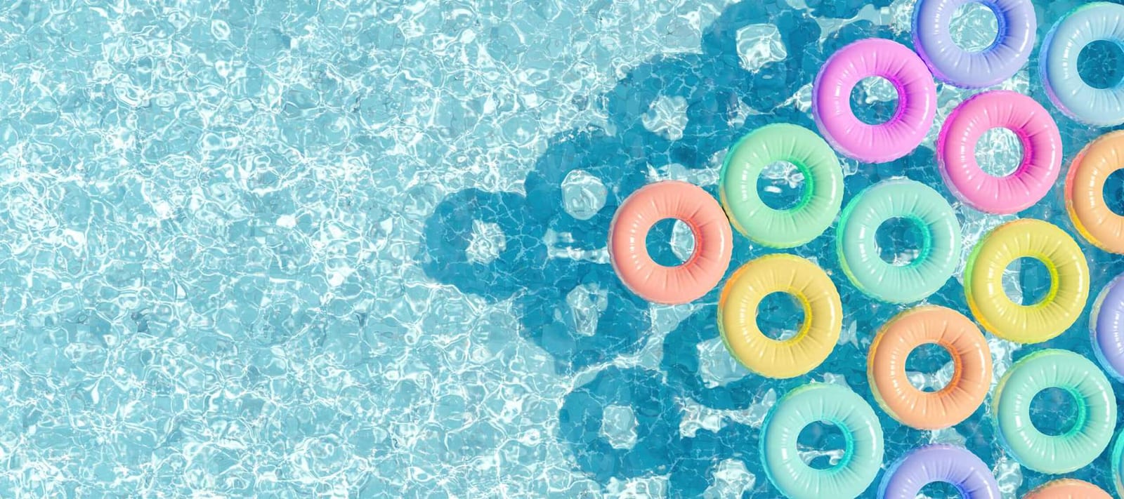 Pastel-colored rings floating on a swimming pool surface